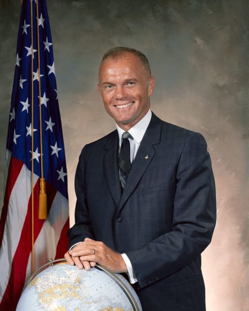 John Glenn in a suit, leaning against a globe in his official Mercury 7 portrait