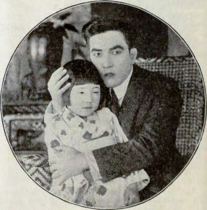 A still from the American drama film A Heart in Pawn (1919) with Sessue Hayakawa and an unidentified child actor, on page 40 of the 22 March 1919 issue of Exhibitors Herald.