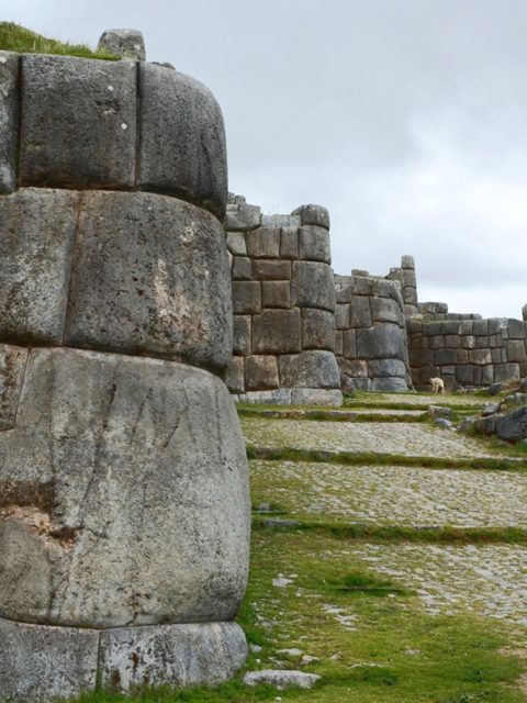 A photo showing the exterior wall of Sacsayhuaman, an Inca stronghold of Cusco. It illustrates how the huge pieces of rock fit perfectly together, By Christophe Meneboeuf, CC BY-SA 2.5
