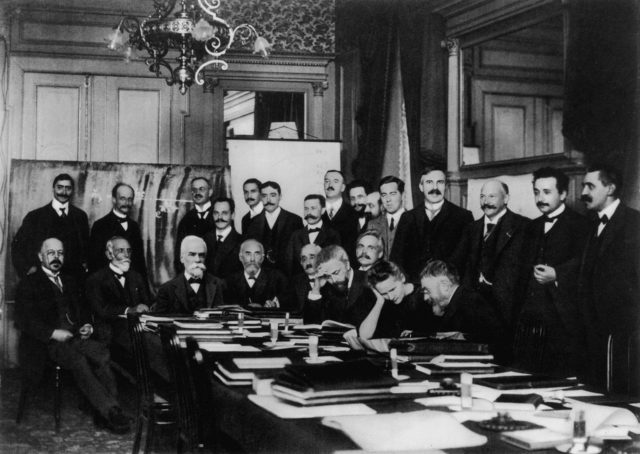Photograph of the first conference in 1911 at the Hotel Metropole. Seated (L-R): W. Nernst, M. Brillouin, E. Solvay, H. Lorentz, E. Warburg, J. Perrin, W. Wien, M. Curie, and H. Poincaré. Standing (L-R): R. Goldschmidt, M. Planck, H. Rubens, A. Sommerfeld, F. Lindemann, M. de Broglie, M. Knudsen, F. Hasenöhrl, G. Hostelet, E. Herzen, J.H. Jeans, E. Rutherford, H. Kamerlingh Onnes, A. Einstein and P. Langevin.