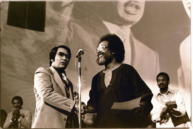 Jim Jones receives a Martin Luther King, Jr. Humanitarian award from Pastor Cecil Williams, 1977. Author: Nancy Wong CC BY-SA 4.0