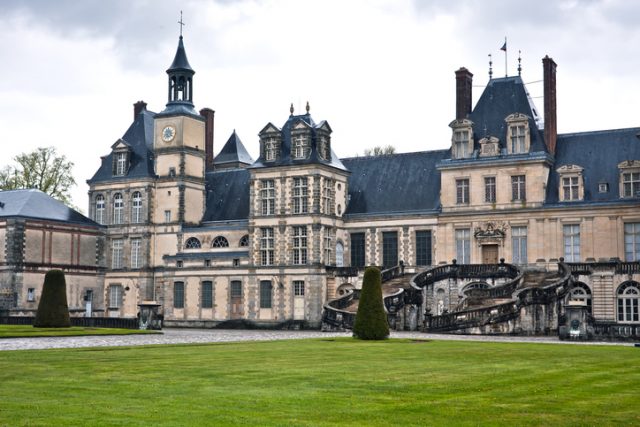 Paris, France – April 25, 2012: Chateau de Fontainebleau on a rainy day. This is one of the largest royal palace in France situated close to Paris near the famous Forest of Fontainebleau, a former royal hunting park.