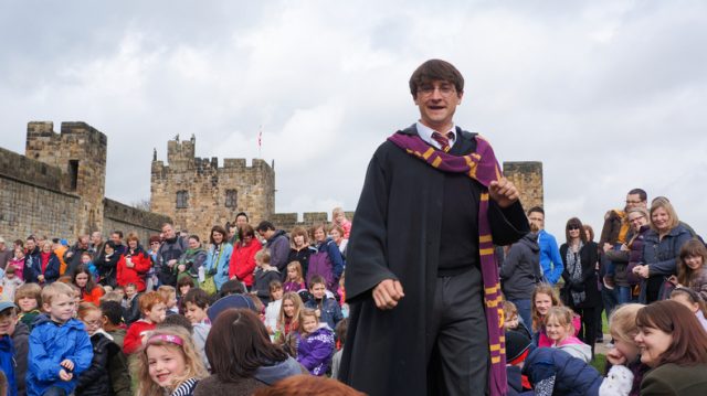 “Alnwick, England – April 02, 2012: A male actor playing the role of film hero Harry Potter to entertain tourists at Alnwick castle in Northumberland England. This castle was used to film parts of the movies”
