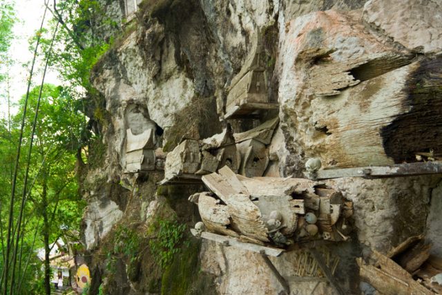 Semi-open graves hang from the side of a cliff in Rantepao, Sulawesi, Indonesia