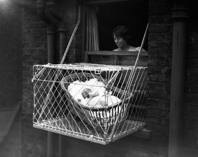 Baby in Cage Hung Out of Window (Photo by © Hulton-Deutsch Collection/CORBIS/Corbis via Getty Images)