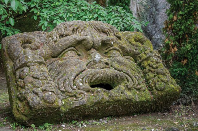 View of sculpture amidst the vegetation in the Park of Bomarzo. Also known as Park of Monsters, it was created to surprise the visitor with surrealistic works in stone. Lazio region, central Italy