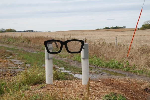 A roadside sign in the form of Buddy Holly’s glasses, located close to the location where he was killed in a plane crash on February 3, 1959 – The Day the Music Died Photo:Dsapery CC BY 3.0