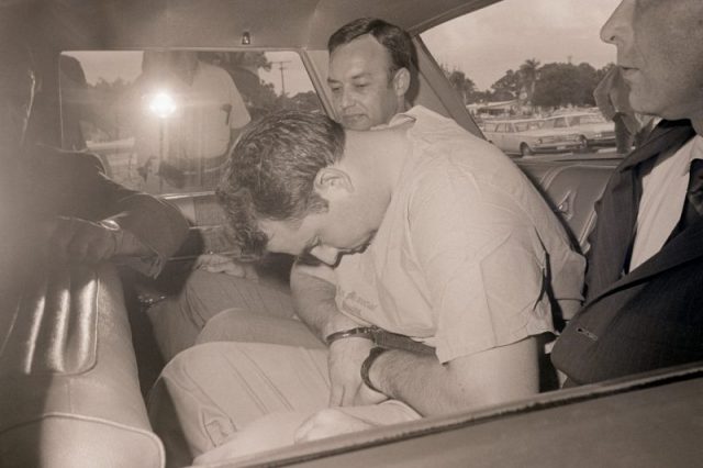 L- Gary Steven Krist sits dejectedly in an FBI car after being brought out of Lee Memorial Hospital where he stayed since his capture in a marsh late 12/21 near Punta Gorda. Krist is being charged with the kidnapping of Barbara Jane Mackle of Miami 12/17 in Atlanta, GA. Krist was put under $500,000 bond, the same amount he allegedly demanded and got from the parents of Barbara Jane. Getty Images