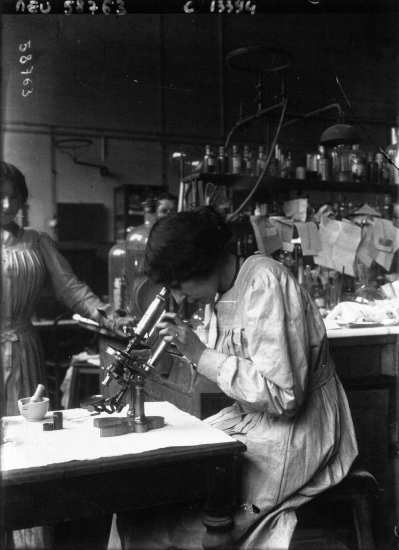 Woman looking through a microscope at the municipal laboratory Paris France