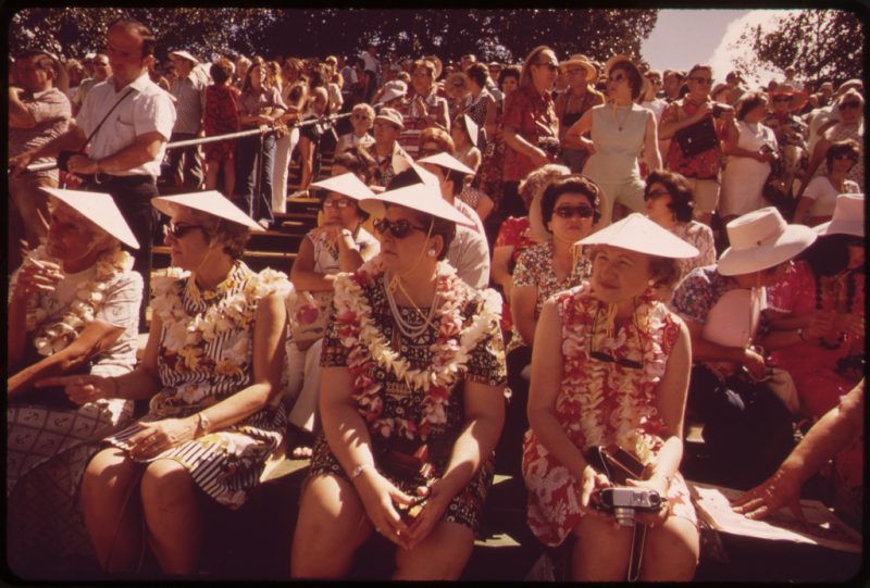 Tourists at a hula dance demonstration. Those who do the dance are rewarded with leis