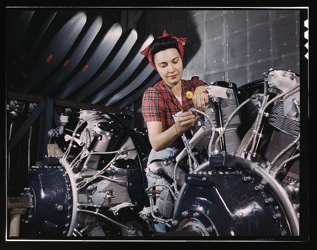 Woman working on an airplane motor at North American Aviation, Inc., plant in Calif