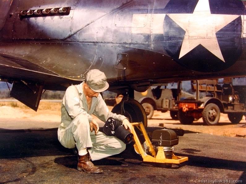 Sgt. installs a K-25 camera in a Bell P-39.