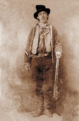 Portrait of American gunman Billy the Kid (1859–1881). Image mirrored on vertical axis to correct widely-seen flopped tintype. Cartridge loading gate on Winchester Model 1873 lever action rifle is on the right side of the receiver.