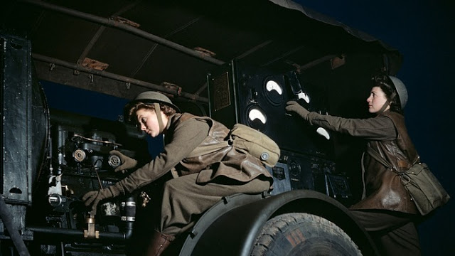 Two Auxiliary Territorial Service girls operate a mobile power plant on an anti-aircraft gun site at night