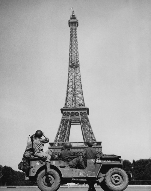 American soldiers watch the French flag flying on the Eiffel Tower, c. 25 August 1944.Source