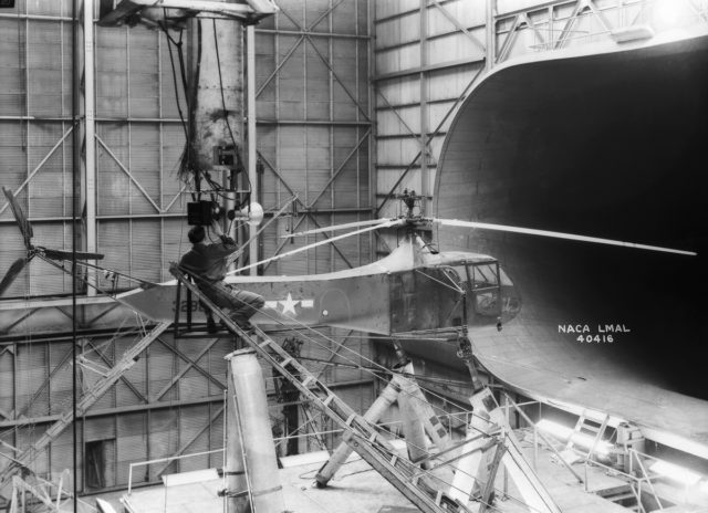 One of Langley's Sikorsky YR-4B/HNS-1 helicopters is seen in the 30 x 60 Full Scale Tunnel. The technician is setting up camera equipment for stopped-action rotor-blade photos. Sikorsky built hundreds of R-4 helicopters during World War II. It was the first mass-produced helicopter.