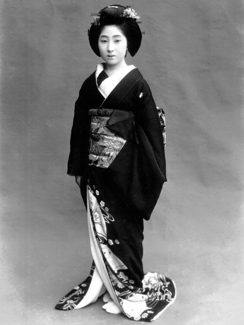 A geisha dressed for performing tea ceremony, the outfit resembles that of a maiko. The turned collar (red showing) marks her as a geisha dressed for tea ceremony.Source