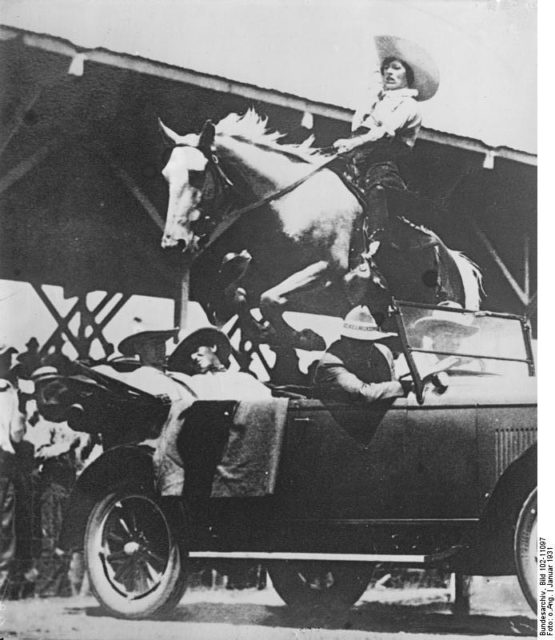 A-daring-leap-of-a-cowgirl-over-a-car-with-4-passangers. By Bundesarchiv, Bild 102-11097 / CC-BY-SA 3.0, CC BY-SA 3.0 de, https://commons.wikimedia.org/w/index.php?curid=5415240