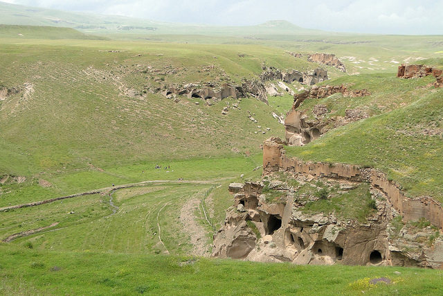 A gorge below Ani, showing numerous caves dug into cliffs, as well as fortifications. Source