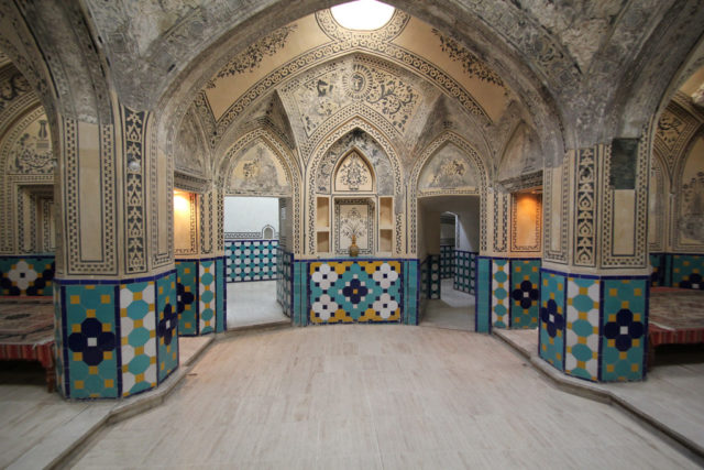 It is decorated with ornamental tiles, some of which are turquoise and gold. Source