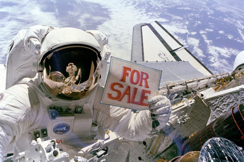 A NASA astronaut jokingly advertises a recovered defective satellite for sale during a space walk