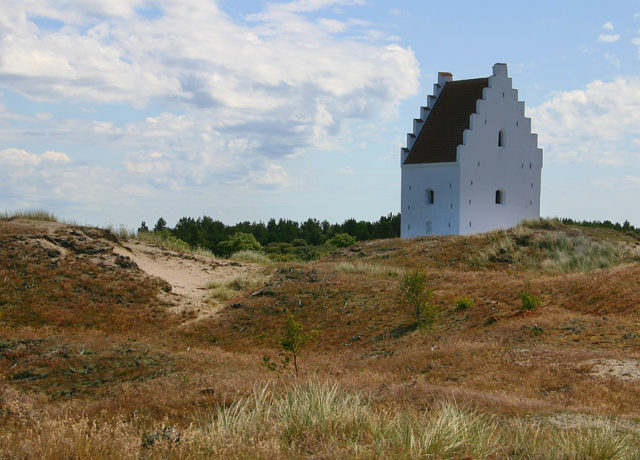 Nowadays only the church tower still stands, rising above the sandy dunes. Photo Credit