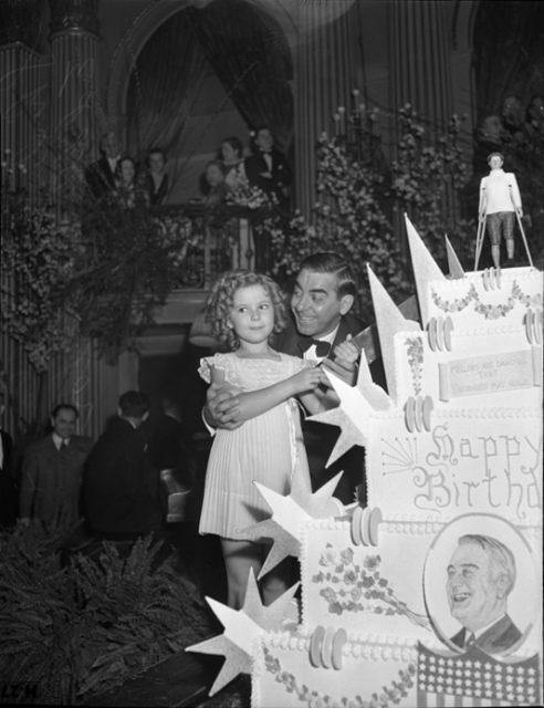 Shirley Temple and Eddie Cantor cutting President Franklin D. Roosevelt's birthday cake in Los Angeles, California, 1937 
