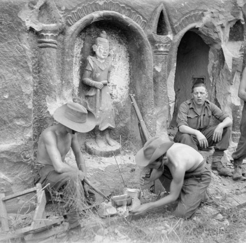 Men of the Wiltshire Regiment from the 26th Indian Infantry Division prepare a meal beside a temple on Ramree Island.