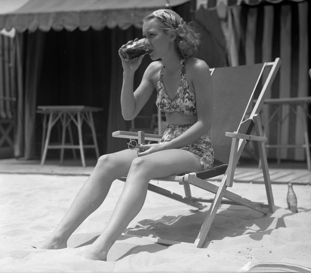 Academy Award winning actress Jane Wyman on a California beach in a two-piece swimsuit that bares the legs and midriff