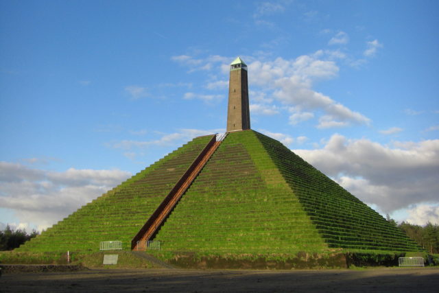 The current pyramid is composed of lush grass-covered steps leading up to the crowning obelisk. Photo Credit