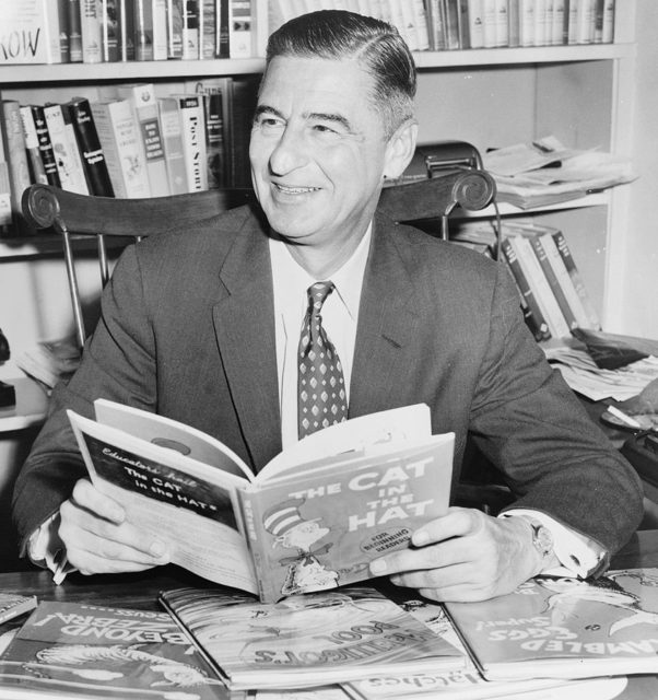 Theodor Seuss Geisel, holding 'The Cat in The Hat'. 1957