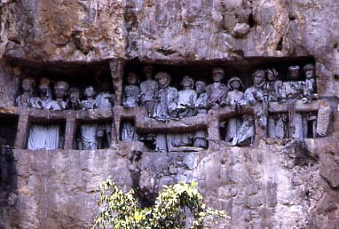 A stone-carved burial site. Tau tau (effigies of the deceased) were put in the cave, looking out over the land. Photo Credit