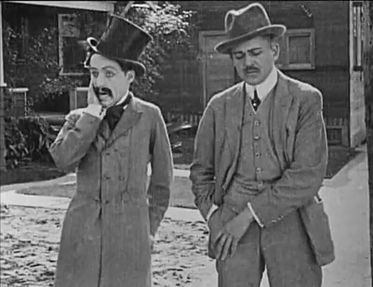 Chaplin (left) in his first film appearance, Making a Living (1914)