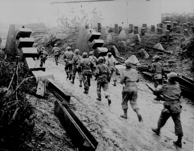 United States Army troops passing through dragon's teeth on the Siegfried Line in 1944. Photo Credit