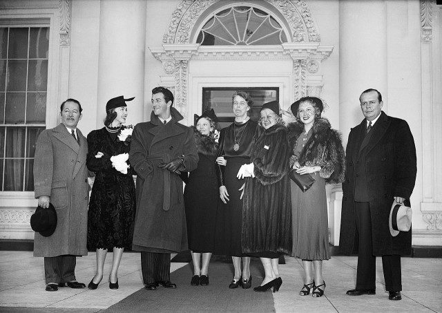Jean Harlow standing beside Eleanor Roosevelt, with other celebrities invited to Washington, DC, for the President’s Birthday Ball (January 30, 1937) Photo Credit 