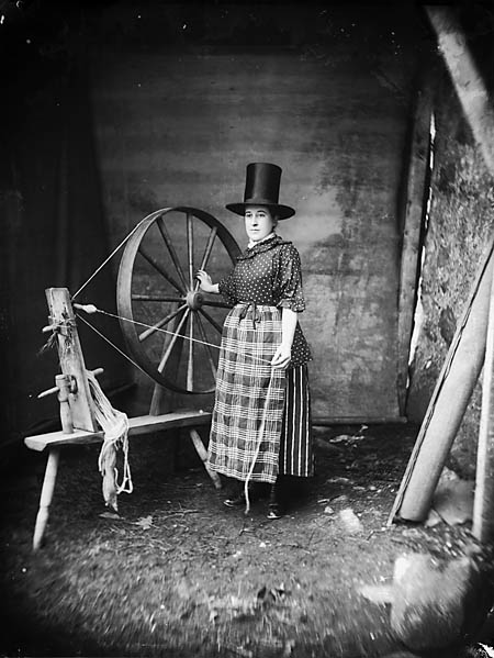 Woman in Welsh national dress with a spinning wheel in 1885