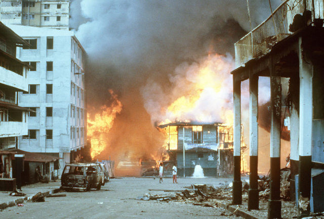 Flames engulf a building following the outbreak of hostilities between the Panamanian Defense Force and U.S. forces during the operation. 20,000 were displaced from their homes. Disorder continued for nearly two weeks.