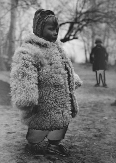 A Polish girl wears a heavy-sheepskin-coat at a refugee camp Photo Credit