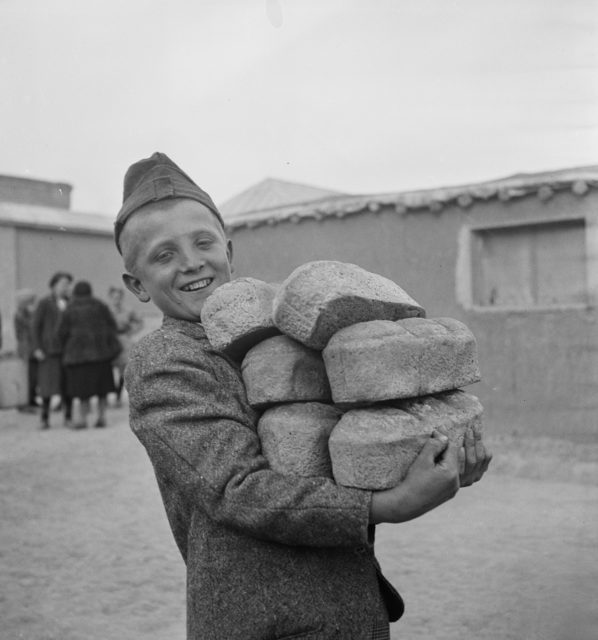 A Polish boy carries loaves of bread provided by the Red Cross Photo Credit