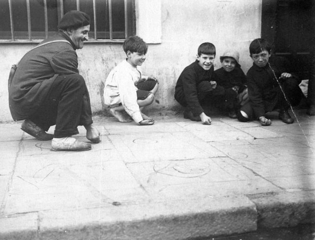 Boys playing Marbles on the sidewalk, Buenos Aires, Argentina.
