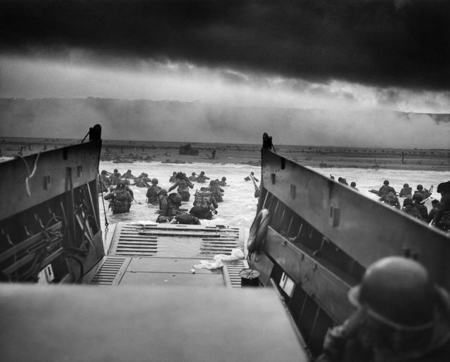 An LCVP (Landing Craft, Vehicle, Personnel), from the U.S. Coast Guard-manned USS Samuel Chase, disembarks the E Company troops, 16th Infantry Regiment, onto the Fox Green section of Omaha Beach on the morning of June 6, 1944. During the initial landing two-thirds of Company E became casualties.