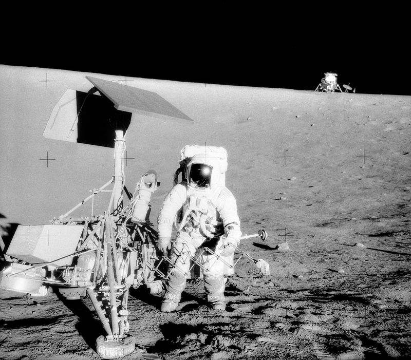 Pete Conrad, the commander of Apollo 12, stands next to Surveyor 3 lander. In the background is the Apollo 12 lander