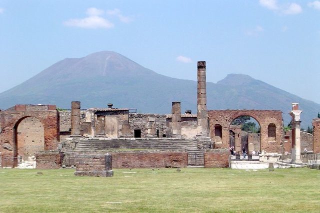 Pompeii, with Vesuvius towering above Photo Credit