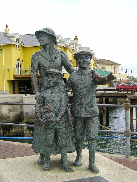 Statue of Annie Moore and her brothers on the quayside in Cobh, Ireland. Photo Credit