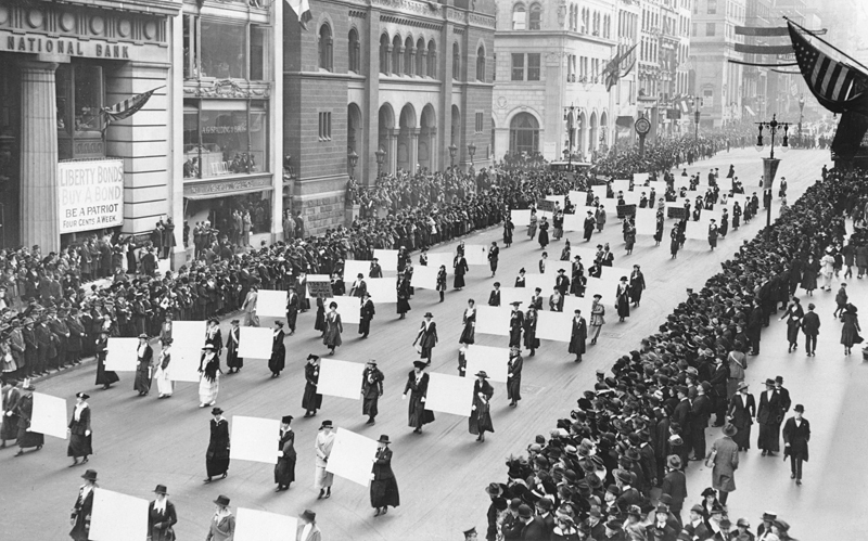 Women’s suffragists parade in New York City in 1917, carrying placards with signatures of more than a million women
