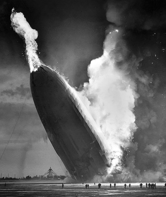 The fire bursts out of the nose of the Hindenburg.