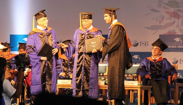 Student receiving academic degree from Azim Premji during a Graduation ceremony in ISB. Adi Godrej in the background. Recipient and donors in “convocation dress”. Photo Credit