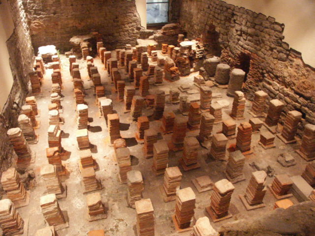 Caldarium from the Roman Baths at Bath, in Britain. The floor has been removed to reveal the empty spaces through which the hot air would flow   Photo Credit