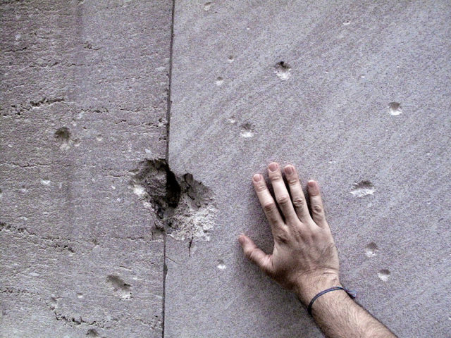 Remnants of the damage from the 1920 bombing are still visible on 23 Wall Street. Photo Credit