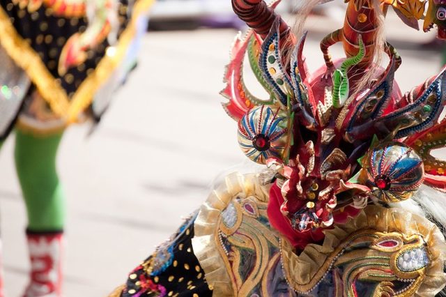 A Diablada dancer wearing a devil mask. Photo credit